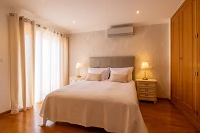 Double bed, bedside lamps and wardrobe in the Sé Catedral room.