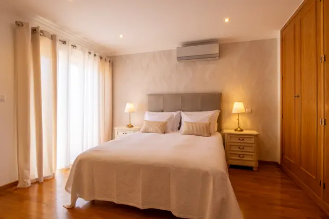 Double bed, bedside lamps and wardrobe in the Sé Catedral room.