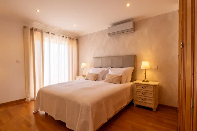 View of the double bed and balcony door from the room entrance.