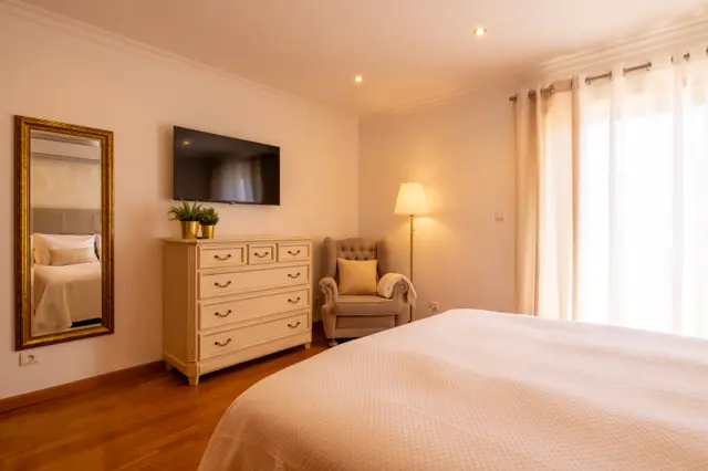 Wall TV, chest of drawers and armchair in the Sé Catedral room.