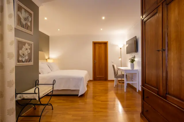 Full view of the room with bed, desk and wardrobe.