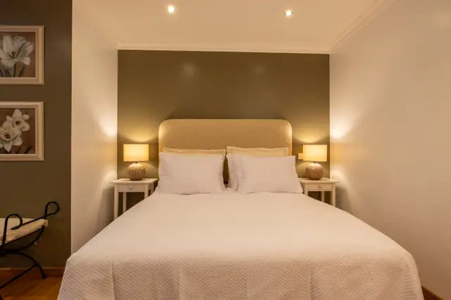 Double bed centred between two bedside tables with lit lamps.