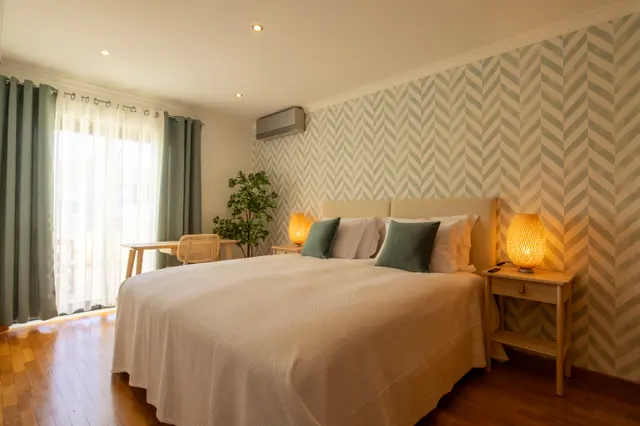 Double bed against patterned wall beside the terrace door.