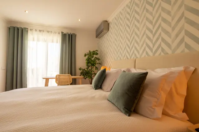 Bedroom with double bed and curtained door to the terrace.