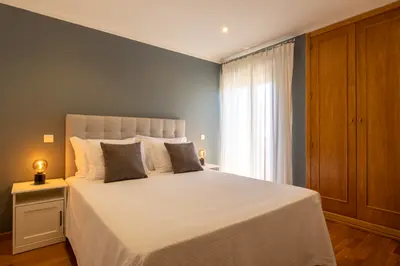 Double bed with wardrobe and curtained balcony door.